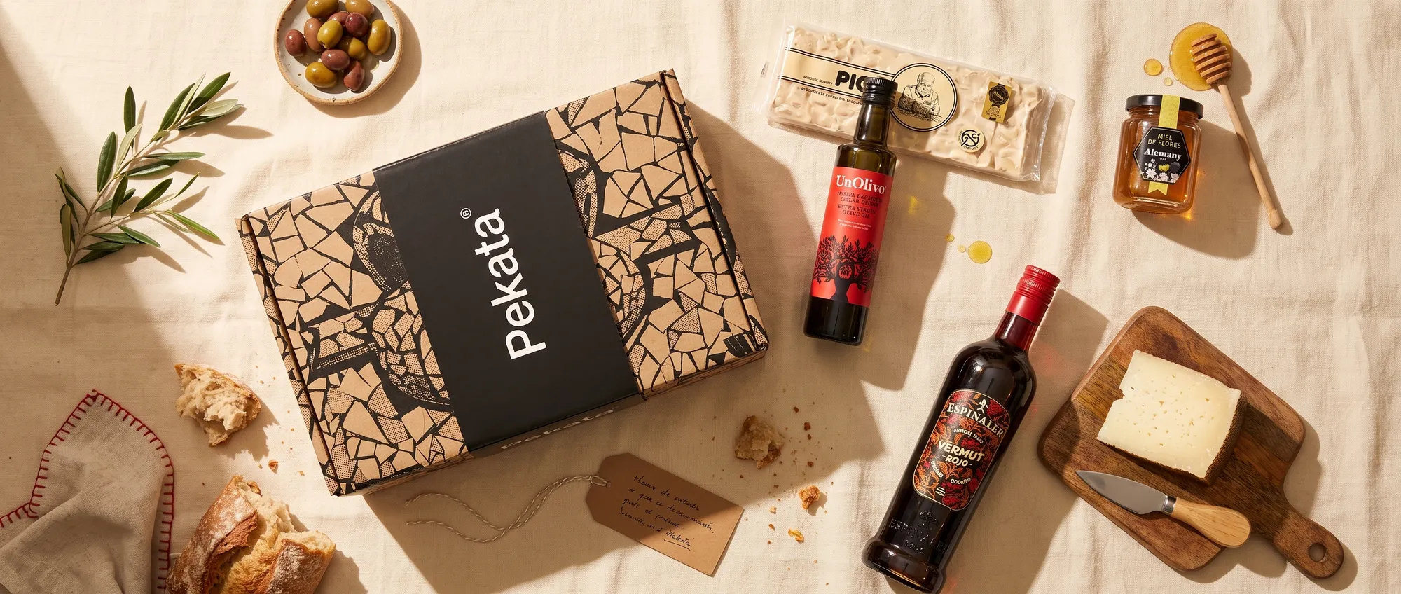 Pekata kerstpakketdoos met ambachtelijke turrón, honing, olie en vermout op een tafel